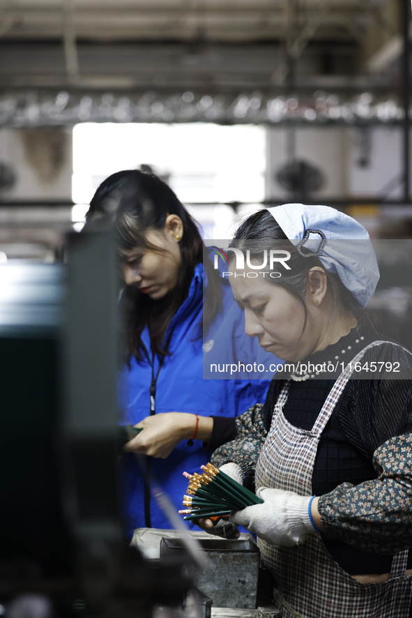 A worker produces pencils at the production workshop of China First Pencil Sihong Co., LTD in Sihong Economic Development Zone in Suqian, Ji...