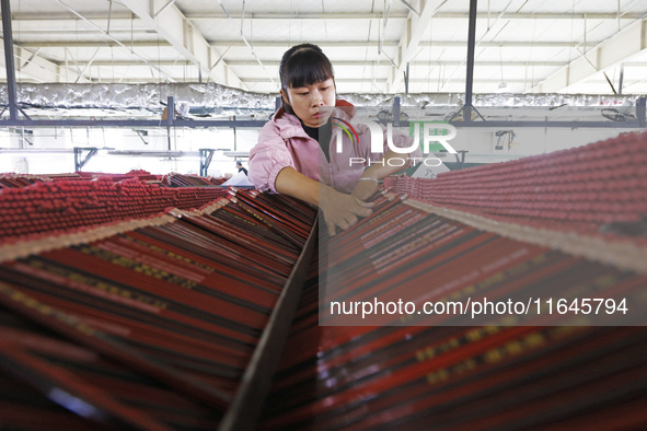 A worker produces pencils at the production workshop of China First Pencil Sihong Co., LTD in Sihong Economic Development Zone in Suqian, Ji...