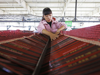 A worker produces pencils at the production workshop of China First Pencil Sihong Co., LTD in Sihong Economic Development Zone in Suqian, Ji...