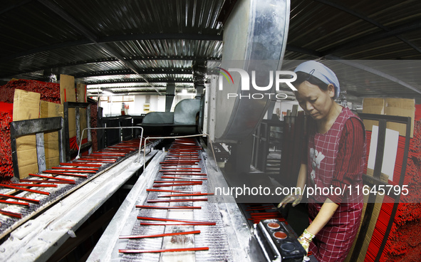 A worker produces pencils at the production workshop of China First Pencil Sihong Co., LTD in Sihong Economic Development Zone in Suqian, Ji...