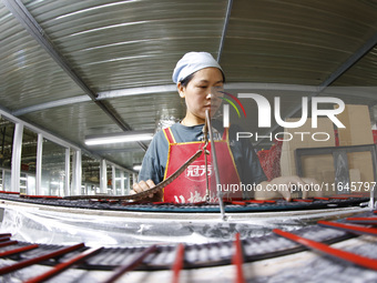 A worker produces pencils at the production workshop of China First Pencil Sihong Co., LTD in Sihong Economic Development Zone in Suqian, Ji...