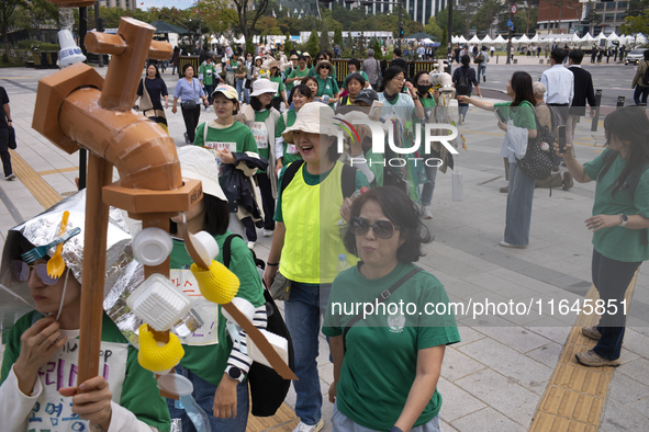 Around 50 participants from Consumer Climate Action and Seoul iCOOP Cooperative gather in front of Daehanmun Gate, Deoksugung Palace, to cal...