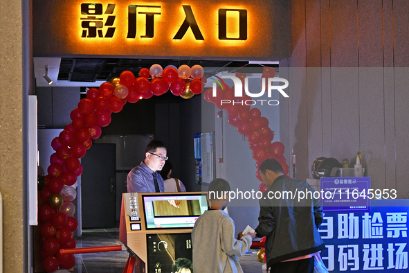 People watch a movie at China Film Digital International Cinema in the Fushan district of Yantai city, East China's Shandong province, on Oc...