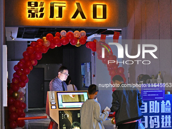 People watch a movie at China Film Digital International Cinema in the Fushan district of Yantai city, East China's Shandong province, on Oc...