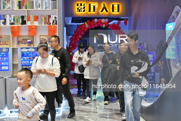 People watch a movie at China Film Digital International Cinema in the Fushan district of Yantai city, East China's Shandong province, on Oc...