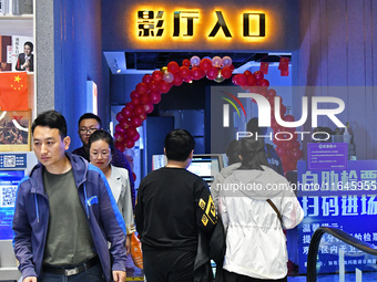 People watch a movie at China Film Digital International Cinema in the Fushan district of Yantai city, East China's Shandong province, on Oc...