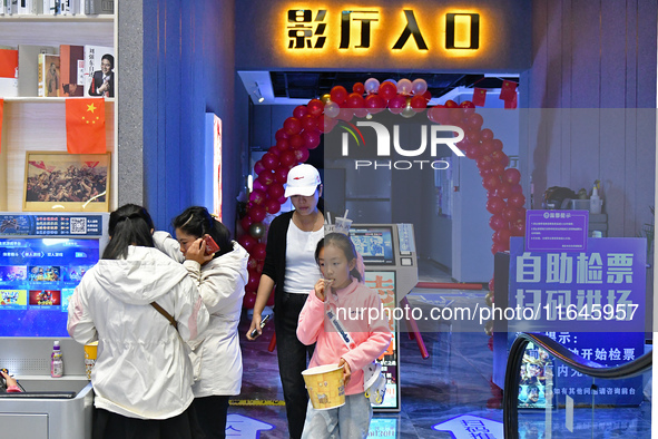 People watch a movie at China Film Digital International Cinema in the Fushan district of Yantai city, East China's Shandong province, on Oc...