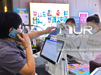 People buy tickets at the China Film Digital International Cinema in the Fushan district of Yantai, China, on October 7, 2024. (