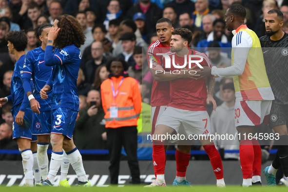 Neco Williams of Nottingham Forest is held back from Marc Cucurella of Chelsea by Murillo of Nottingham Forest during the Premier League mat...