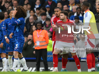 Neco Williams of Nottingham Forest is held back from Marc Cucurella of Chelsea by Murillo of Nottingham Forest during the Premier League mat...