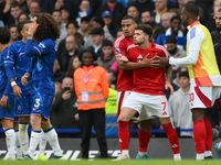 Neco Williams of Nottingham Forest is held back from Marc Cucurella of Chelsea by Murillo of Nottingham Forest during the Premier League mat...