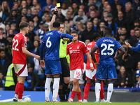 Referee Chris Kavanagh shows a yellow card to Levi Colwill of Chelsea during the Premier League match between Chelsea and Nottingham Forest...