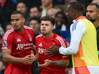 Neco Williams of Nottingham Forest is restrained by Murillo and Willy Boly, both of Nottingham Forest, during the Premier League match betwe...