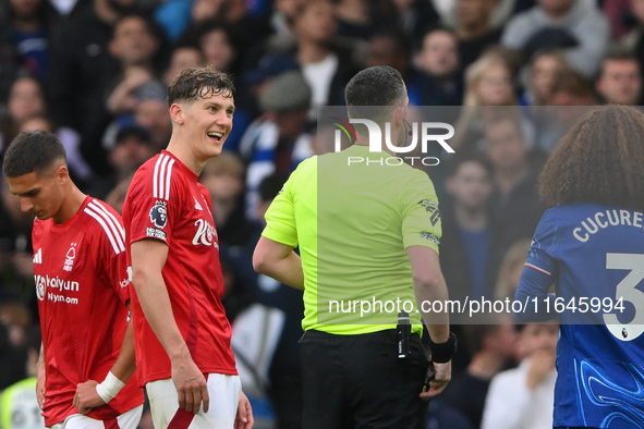 Ryan Yates of Nottingham Forest talks with referee Chris Kavanagh during the Premier League match between Chelsea and Nottingham Forest at S...