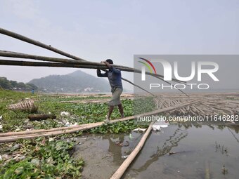 An Indian laborer carries bamboo at a bamboo market on the banks of the Brahmaputra River in Guwahati, India, on April 6, 2018. The Brahmapu...