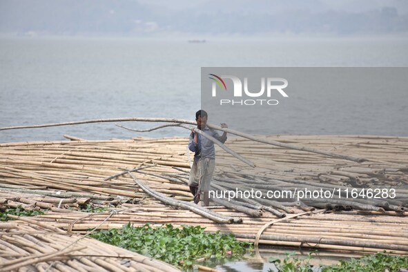 An Indian laborer carries bamboo at a bamboo market on the banks of the Brahmaputra River in Guwahati, India, on April 6, 2018. The Brahmapu...