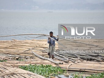 An Indian laborer carries bamboo at a bamboo market on the banks of the Brahmaputra River in Guwahati, India, on April 6, 2018. The Brahmapu...