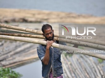 An Indian laborer carries bamboo at a bamboo market on the banks of the Brahmaputra River in Guwahati, India, on April 6, 2018. The Brahmapu...