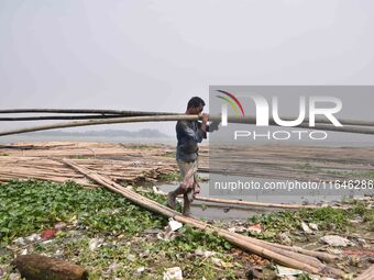 An Indian laborer carries bamboo at a bamboo market on the banks of the Brahmaputra River in Guwahati, India, on April 6, 2018. The Brahmapu...