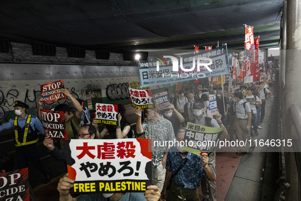 Demonstrators hold placards and show solidarity with Palestinians during the protest against Israeli military actions in Gaza on October 7,...