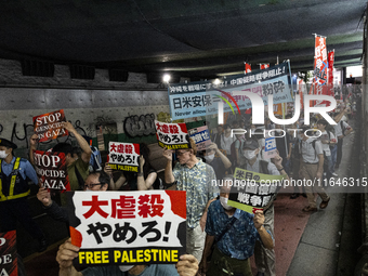 Demonstrators hold placards and show solidarity with Palestinians during the protest against Israeli military actions in Gaza on October 7,...