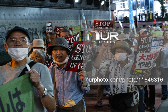 Demonstrators hold placards and show solidarity with Palestinians during the protest against Israeli military actions in Gaza on October 7,...