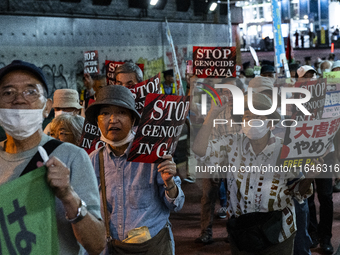 Demonstrators hold placards and show solidarity with Palestinians during the protest against Israeli military actions in Gaza on October 7,...