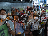 Demonstrators hold placards and show solidarity with Palestinians during the protest against Israeli military actions in Gaza on October 7,...