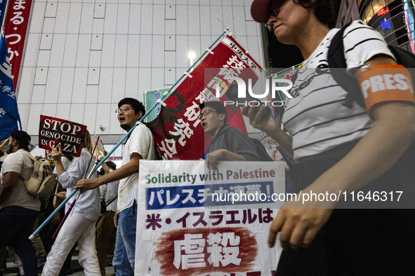 Demonstrators hold placards and show solidarity with Palestinians during the protest against Israeli military actions in Gaza on October 7,...