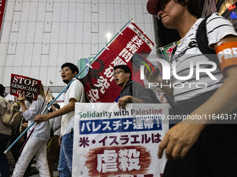 Demonstrators hold placards and show solidarity with Palestinians during the protest against Israeli military actions in Gaza on October 7,...