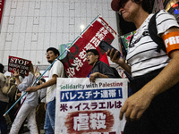 Demonstrators hold placards and show solidarity with Palestinians during the protest against Israeli military actions in Gaza on October 7,...