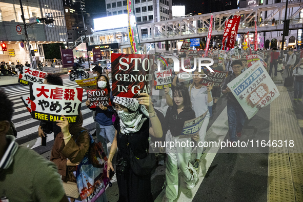 Demonstrators hold placards and show solidarity with Palestinians during the protest against Israeli military actions in Gaza on October 7,...