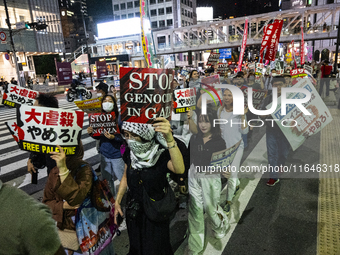 Demonstrators hold placards and show solidarity with Palestinians during the protest against Israeli military actions in Gaza on October 7,...