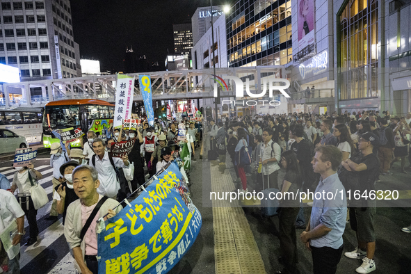 Demonstrators hold placards and show solidarity with Palestinians during the protest against Israeli military actions in Gaza on October 7,...