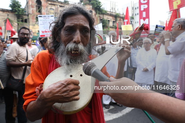 An Indian folk singer sings a song before the Communist Party of India (Marxist), West Bengal starts a protest march amid the ongoing confli...