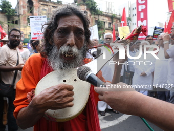 An Indian folk singer sings a song before the Communist Party of India (Marxist), West Bengal starts a protest march amid the ongoing confli...