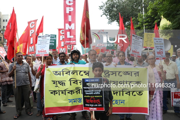 A holds a poster while the Communist Party of India (Marxist), West Bengal, holds posters during a protest amid the ongoing conflict in Gaza...