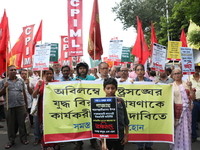 A holds a poster while the Communist Party of India (Marxist), West Bengal, holds posters during a protest amid the ongoing conflict in Gaza...