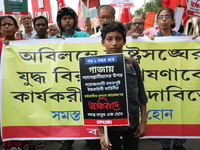 A boy holds a poster while the Communist Party of India (Marxist), West Bengal, holds posters and shouts slogans during a protest march amid...