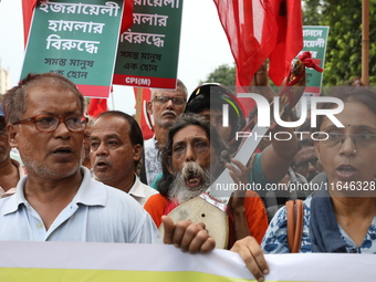 The Communist Party of India (Marxist), West Bengal, holds posters and shouts slogans during a protest march amid the ongoing conflict in Ga...