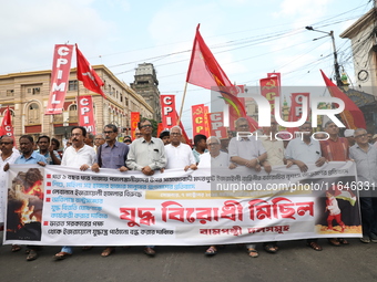 The Communist Party of India (Marxist), West Bengal, holds posters and shouts slogans during a protest march amid the ongoing conflict in Ga...