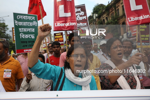 The Communist Party of India (Marxist), West Bengal, holds posters and shouts slogans during a protest march amid the ongoing conflict in Ga...