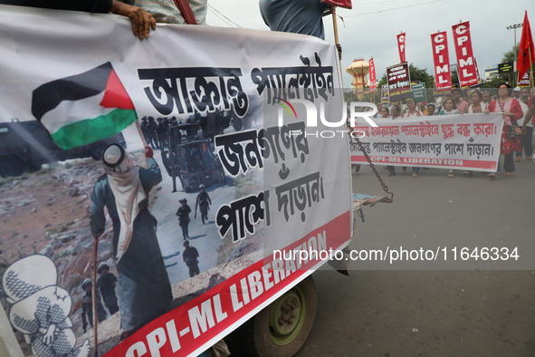 The Communist Party of India (Marxist), West Bengal, holds posters and shouts slogans during a protest march amid the ongoing conflict in Ga...