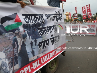 The Communist Party of India (Marxist), West Bengal, holds posters and shouts slogans during a protest march amid the ongoing conflict in Ga...