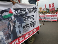 The Communist Party of India (Marxist), West Bengal, holds posters and shouts slogans during a protest march amid the ongoing conflict in Ga...