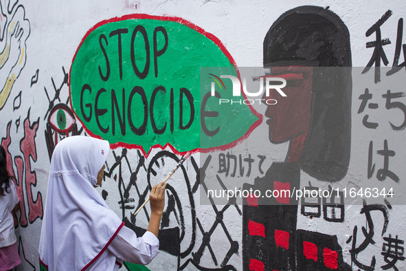 Students paint a mural to support the Palestinian people on a wall in the Liogenteng settlement area in Bandung, West Java, Indonesia, on Oc...