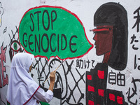 Students paint a mural to support the Palestinian people on a wall in the Liogenteng settlement area in Bandung, West Java, Indonesia, on Oc...