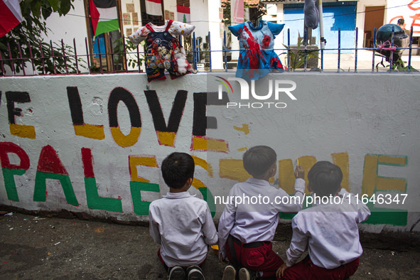 Students paint a mural to support the Palestinian people on a wall in the Liogenteng settlement area in Bandung, West Java, Indonesia, on Oc...