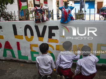 Students paint a mural to support the Palestinian people on a wall in the Liogenteng settlement area in Bandung, West Java, Indonesia, on Oc...