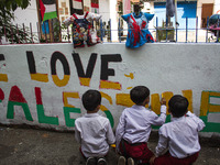 Students paint a mural to support the Palestinian people on a wall in the Liogenteng settlement area in Bandung, West Java, Indonesia, on Oc...